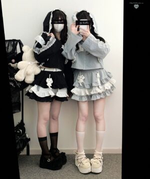 Front mirror selfie of Jirai Kei skirt set with hooded jacket featuring bear charm ornament and layered ruffle construction on models wearing black and gray cropped hoodies