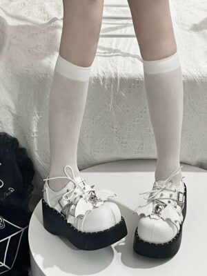 White punk platform loafers straight front view on model wearing white mid-calf socks with lace-up closure and skull decorative buckle detail