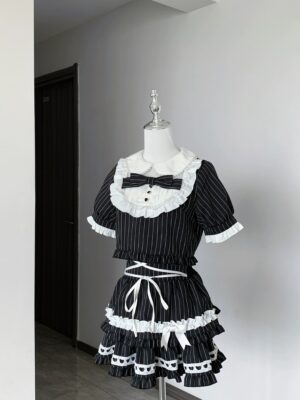 Pinstriped Jirai Kei maid two-piece set front full-body display on mannequin showing white ruffled collar bow tie and lace-up waistband with tiered ruffles