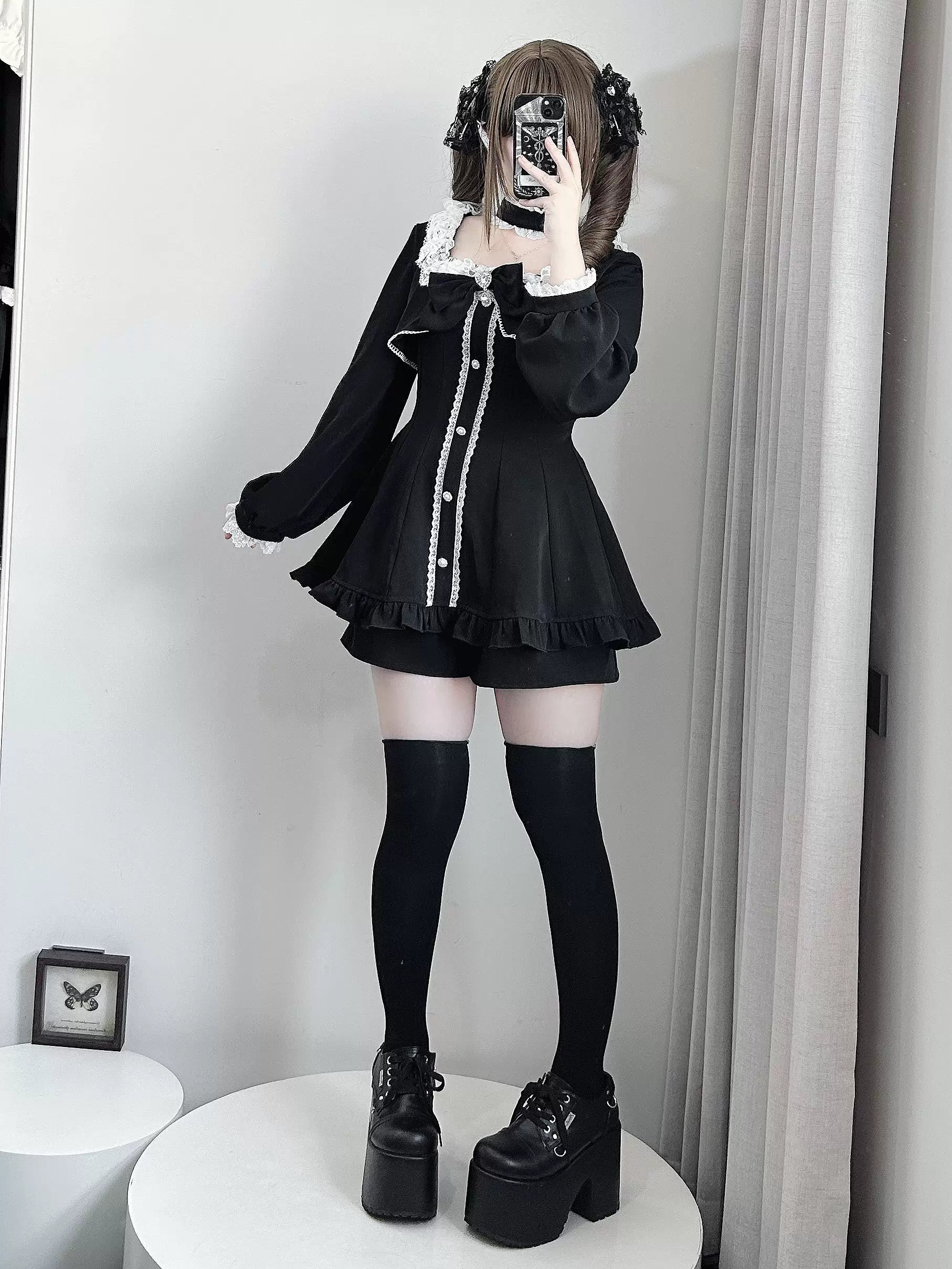 Black Jirai Kei dress with pocketed shorts and removable chest bow, front mirror selfie with puff sleeves, pearl trim, black thigh-high socks and platform boots
