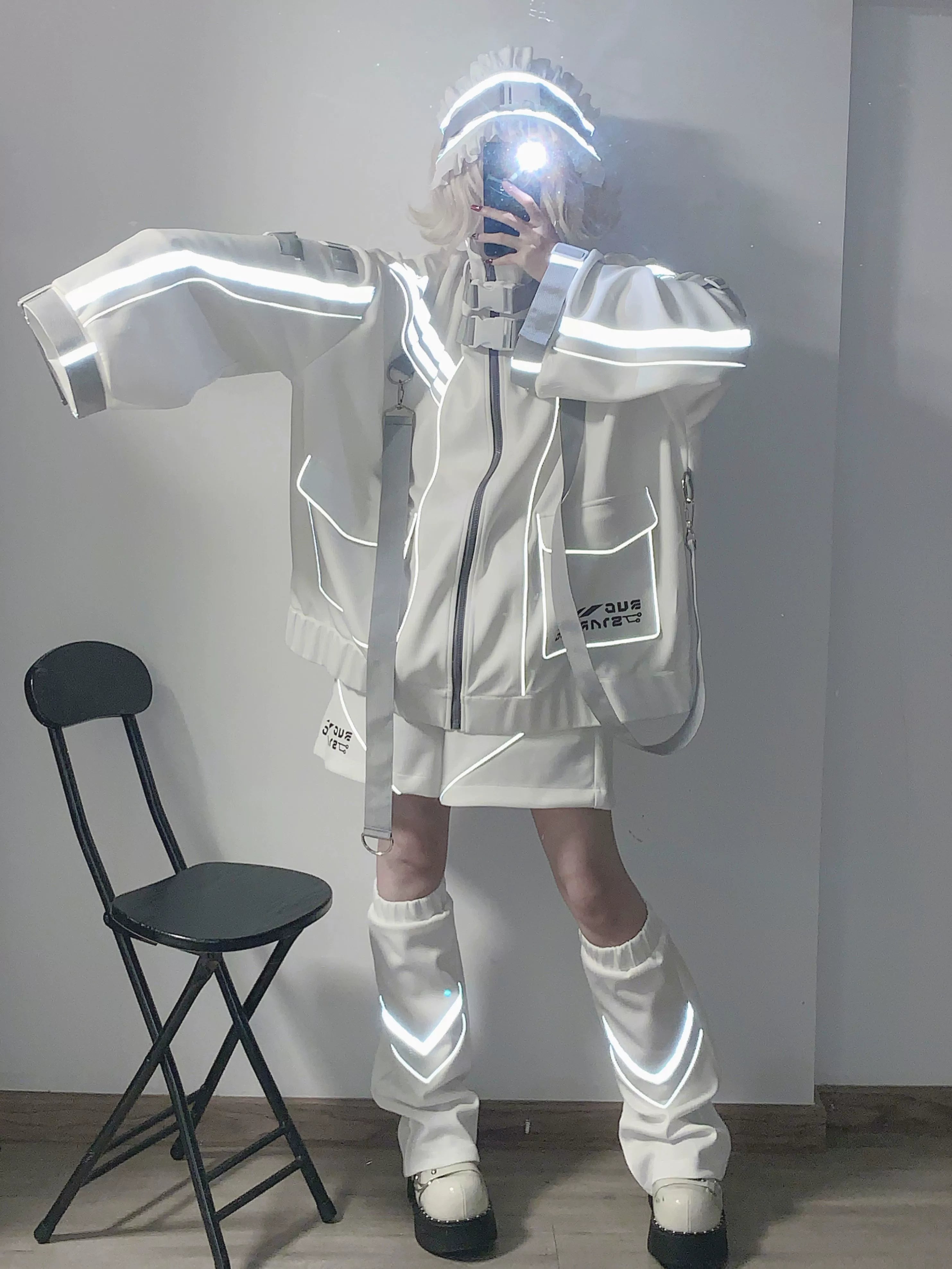 White Jirai Kei oversized punk jacket side view with arms spread showing loose wide sleeves reflective details leg warmers