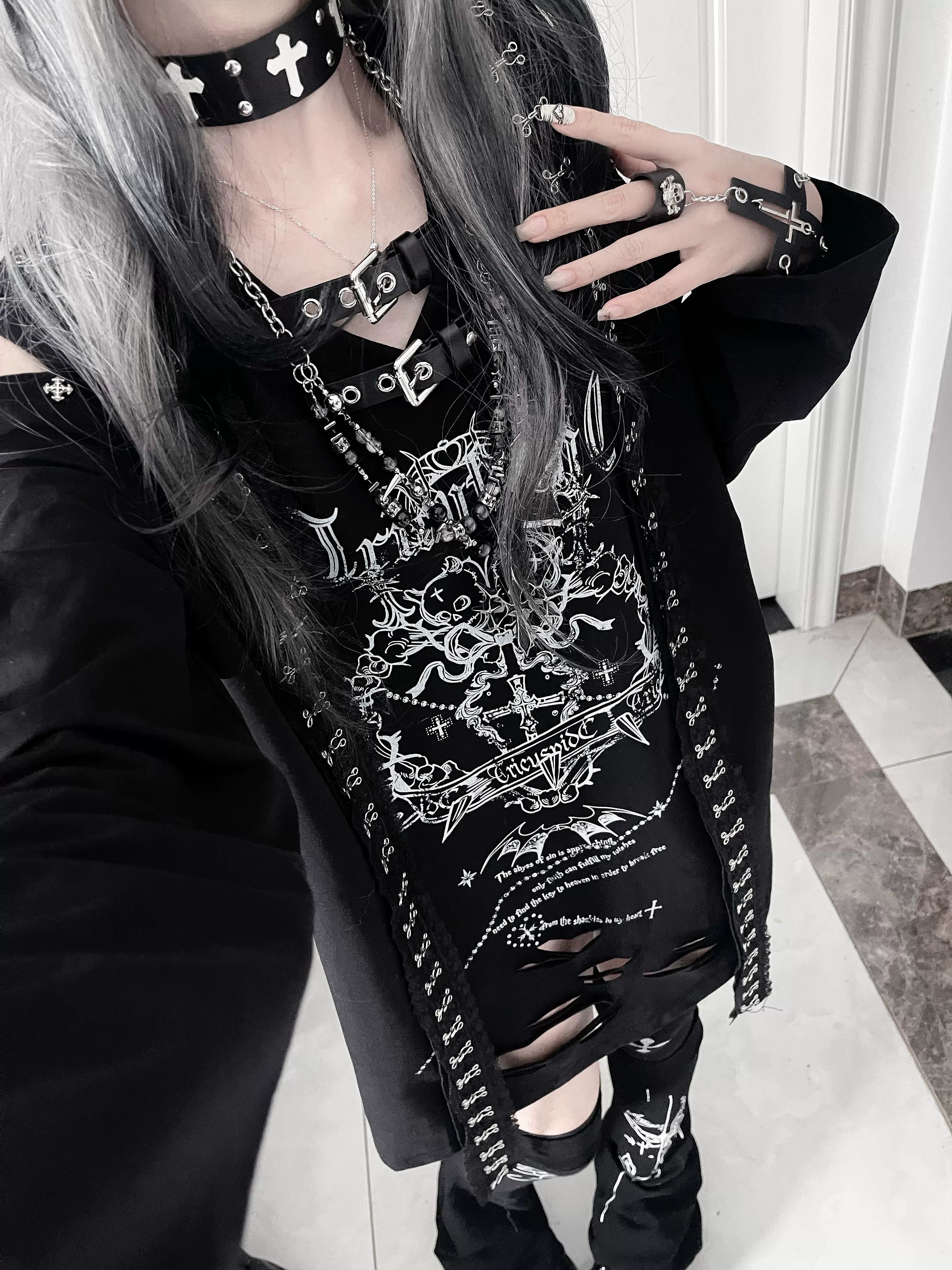 Close-up selfie of black goth subculture long-sleeve top worn with cross choker, layered necklaces and buckle accents, showcasing belted neck collar design detail
