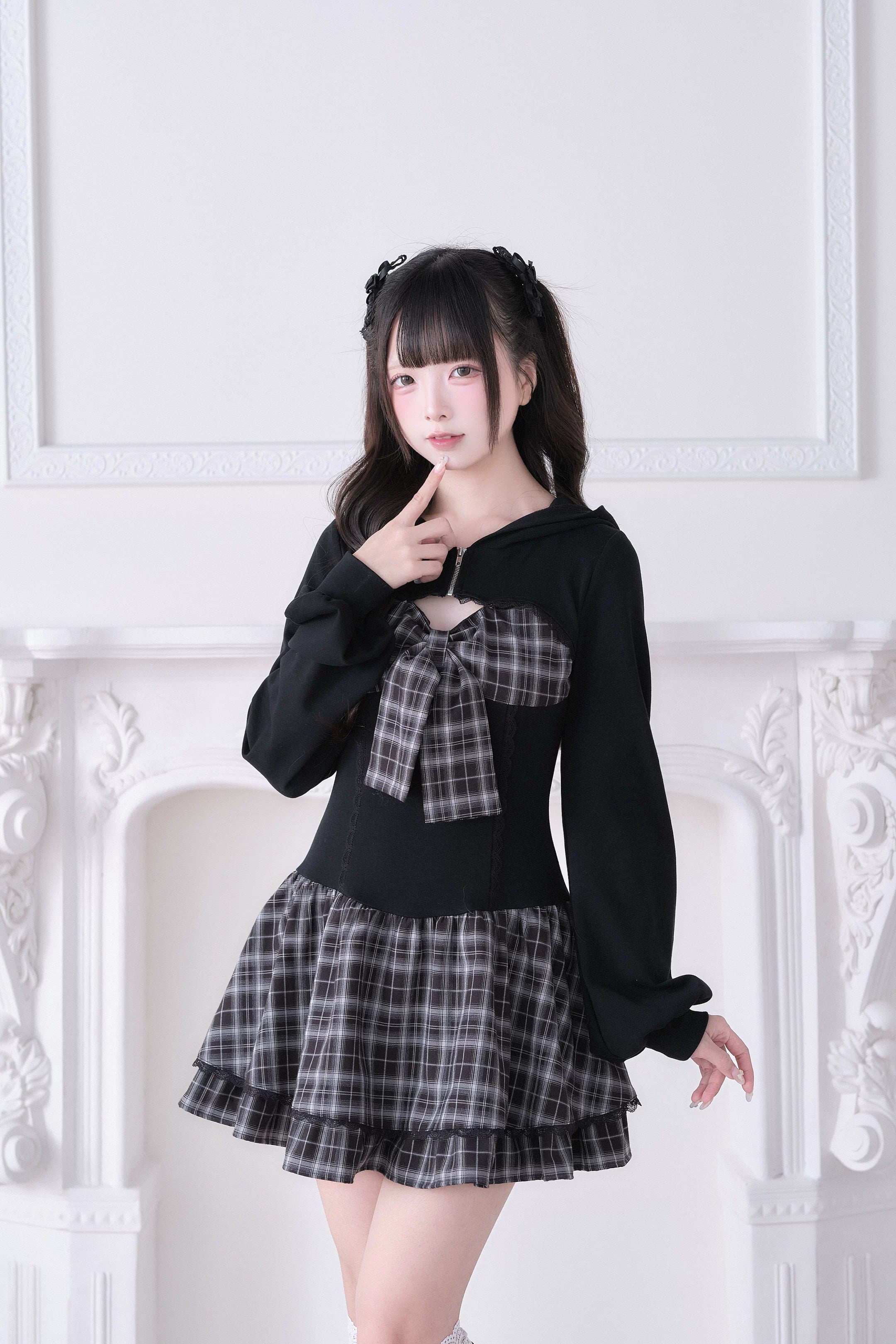 Black plaid Jirai Kei hoodie splice one-piece dress with large plaid bow accent and ruffled mini skirt, front view on model with twin tails