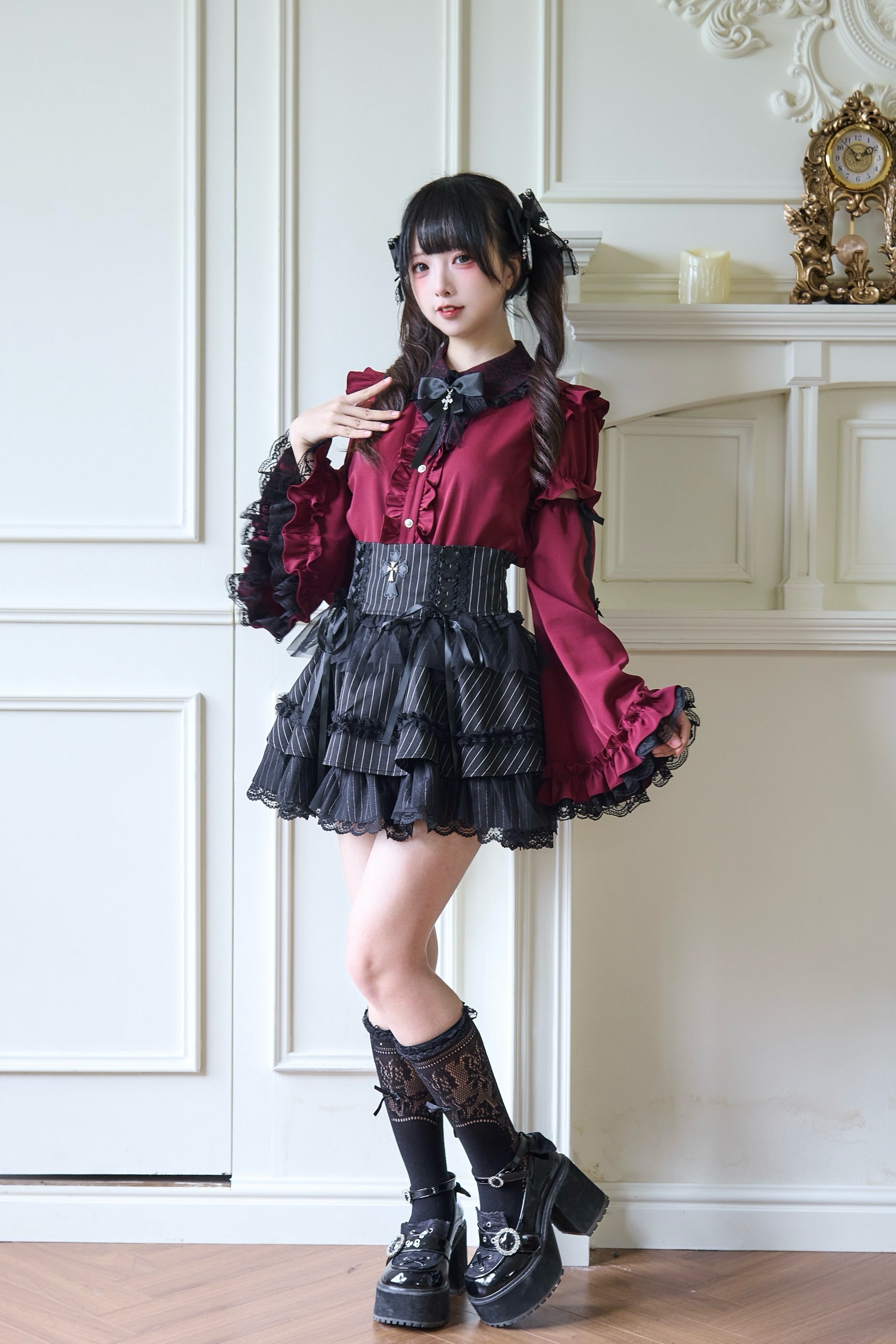 Side front view of burgundy Jirai Kei blouse featuring dramatic ruffled sleeves and structured waistline with black platform boots styling