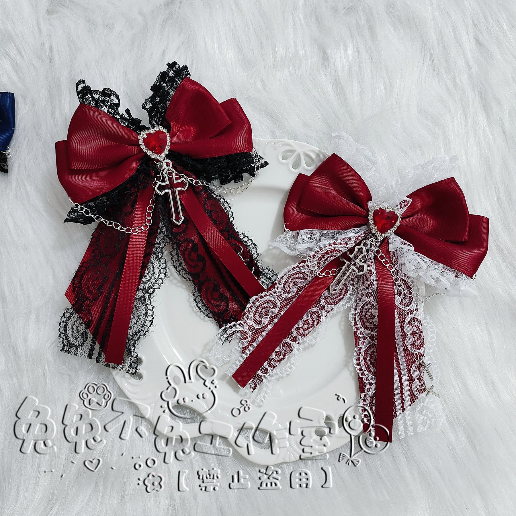 Burgundy-black dual-tone bow hair clips on ceramic plate displaying lace trim, heart and cross metal charms with detailed satin bow construction