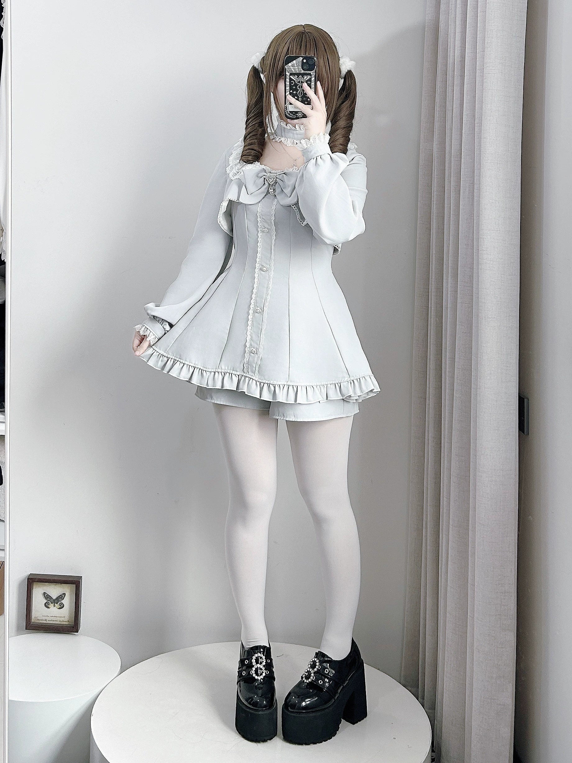 Light gray Jirai Kei dress with pocketed shorts set, front mirror selfie highlighting ruffled hem, white stockings, and platform shoes aesthetic