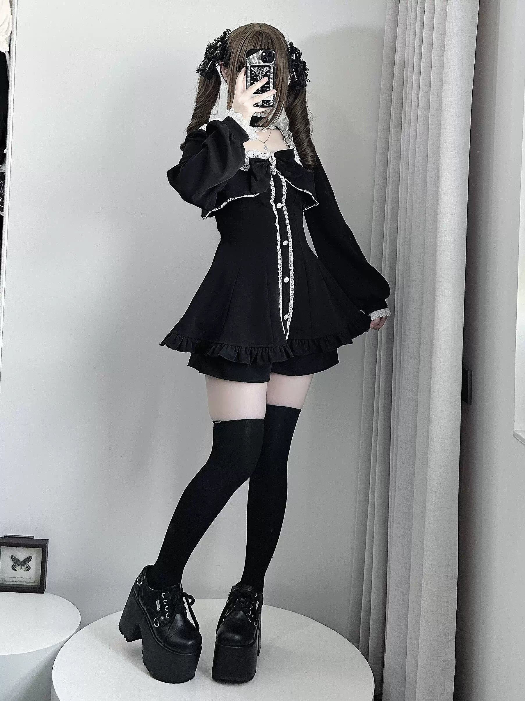 Black gothic Jirai Kei dress and shorts ensemble, side mirror view showcasing ruffled cuffs, pearl embellishments, and black thigh-high socks with platform boots