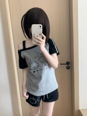 Grey and black Jirai Kei colorblock cold-shoulder t-shirt with cartoon graphics and black printed shorts, mirror selfie model pose