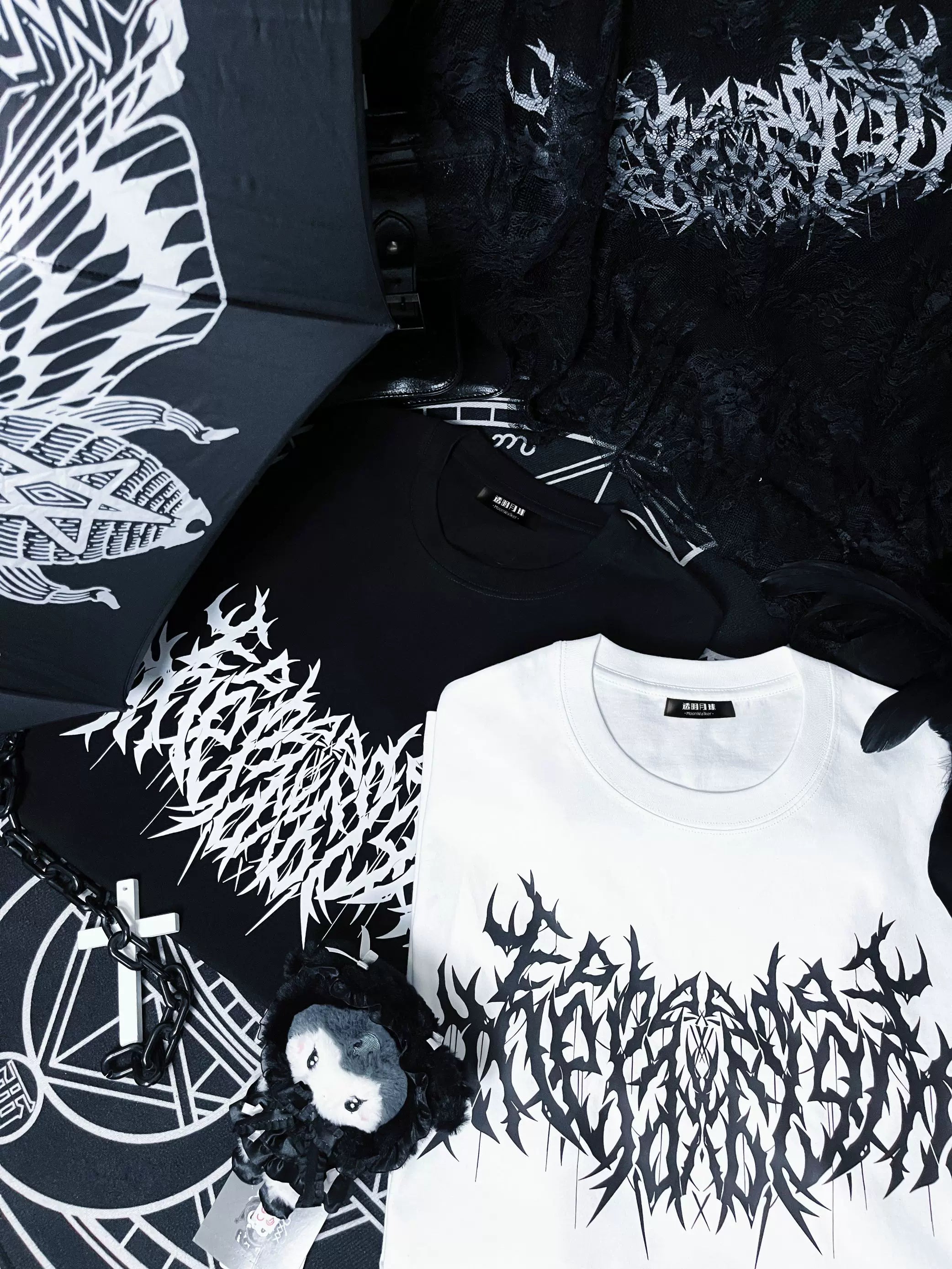 Two gothic print cotton t-shirts black and white jirai kei street style flat lay with cross chain and plush accessories