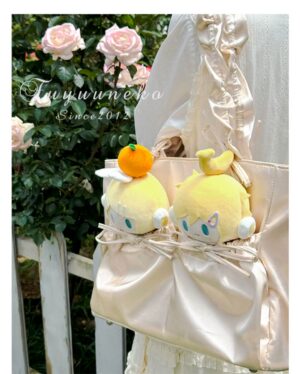 Champagne satin Jirai Kei tote itabag with anime plush doll pockets and glossy satin finish photographed overhead in outdoor garden fence area