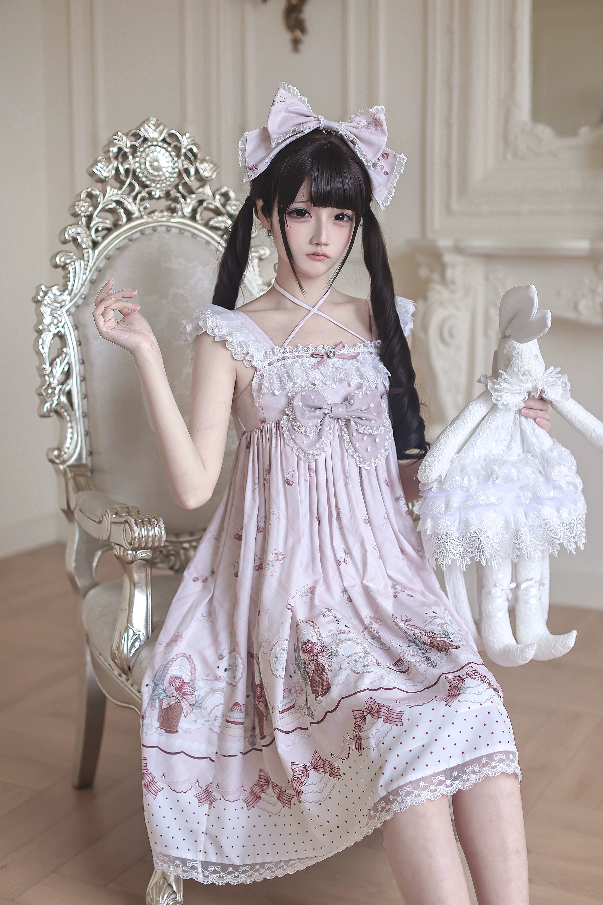 Front close-up to full shot of strawberry bunny Jirai Kei Lolita dress highlighting cross halter neck front chest bow cartoon bunny print and model with rabbit doll