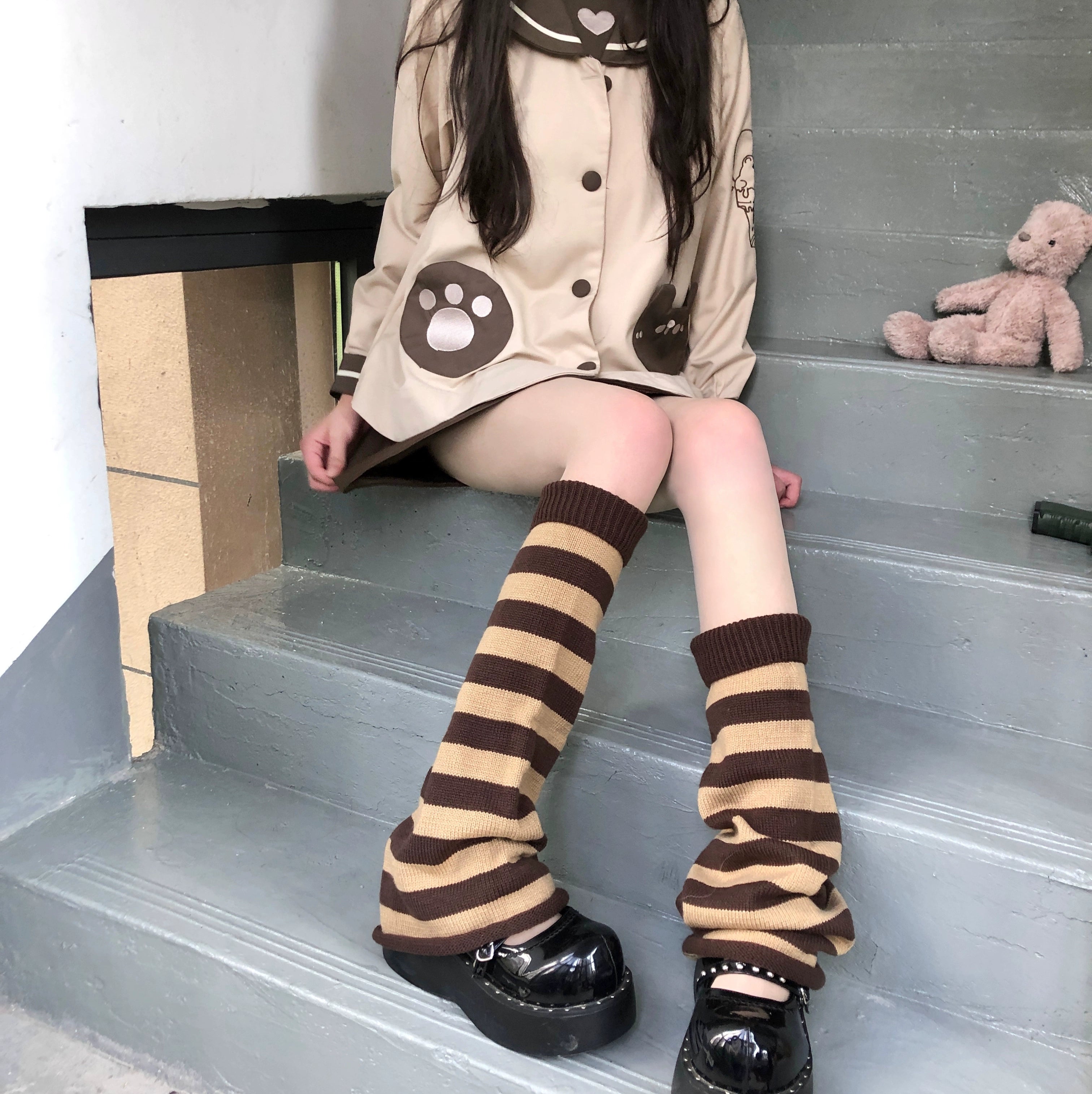 Coffee brown and khaki tan horizontal striped Y2K Jirai Kei leg warmers with slouchy fit three-quarter side view staircase cute coat