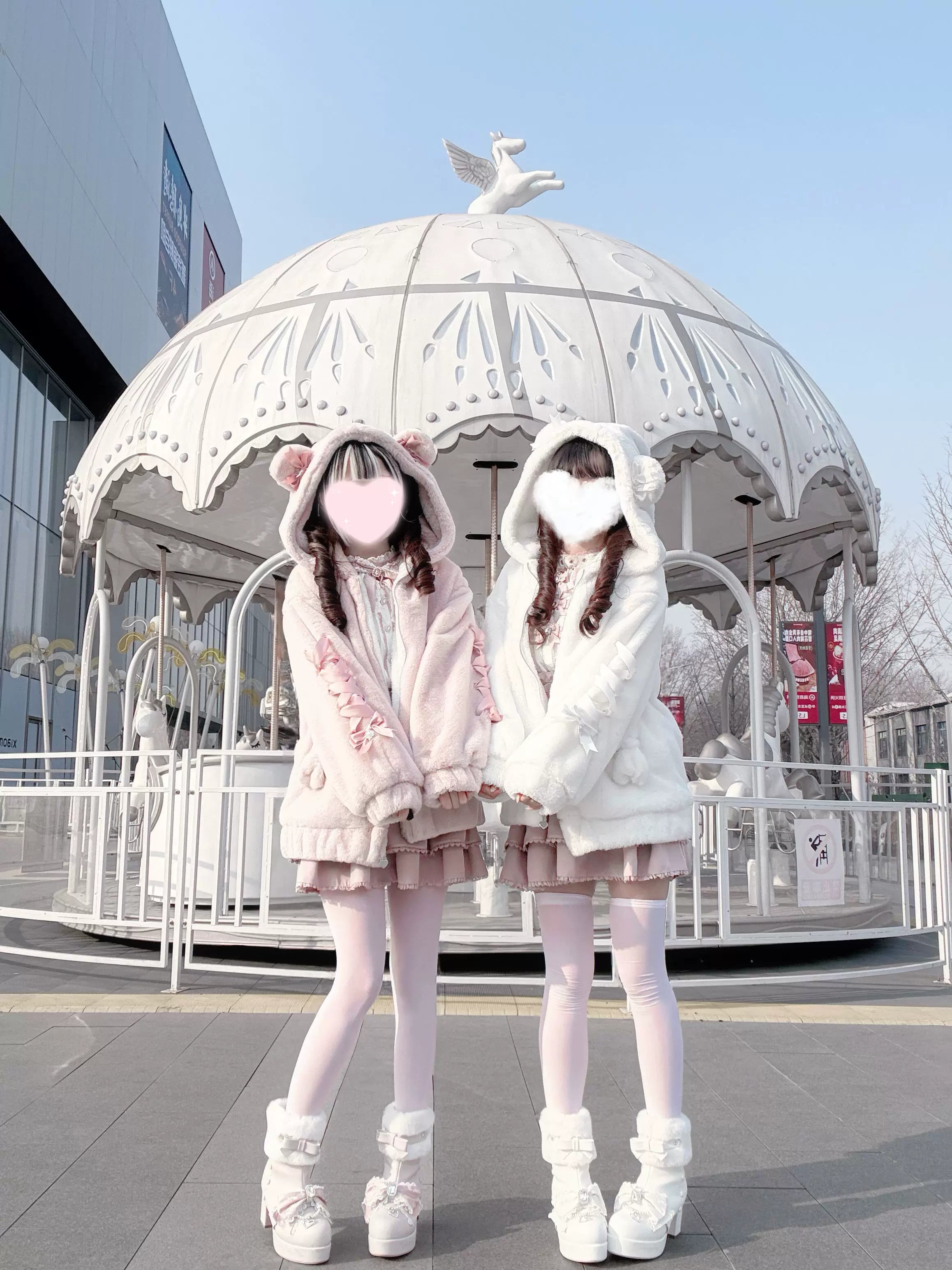 Model adjusting hood of pink Ryousangata bear ear coat showing lolita inner wear and plush fabric quality