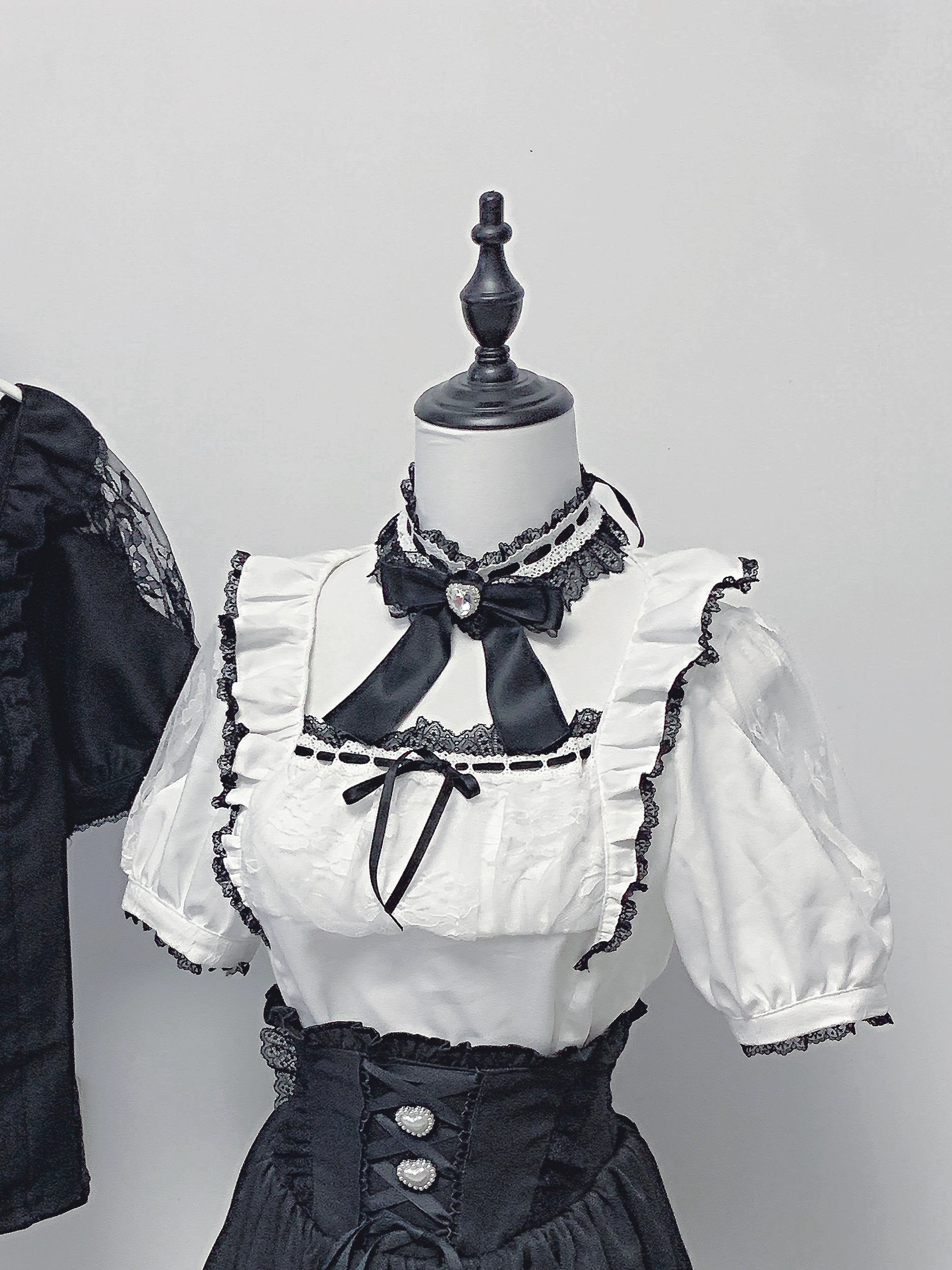 white-jirai-kei-blouse-black-high-waisted-skirt-close-up-view-corset-waist-buttons-ruffled-trim