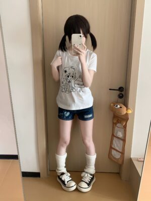 Kawaii anime graphic white t-shirt full-length on model with hand on chest posing in home doorway mirror reflection