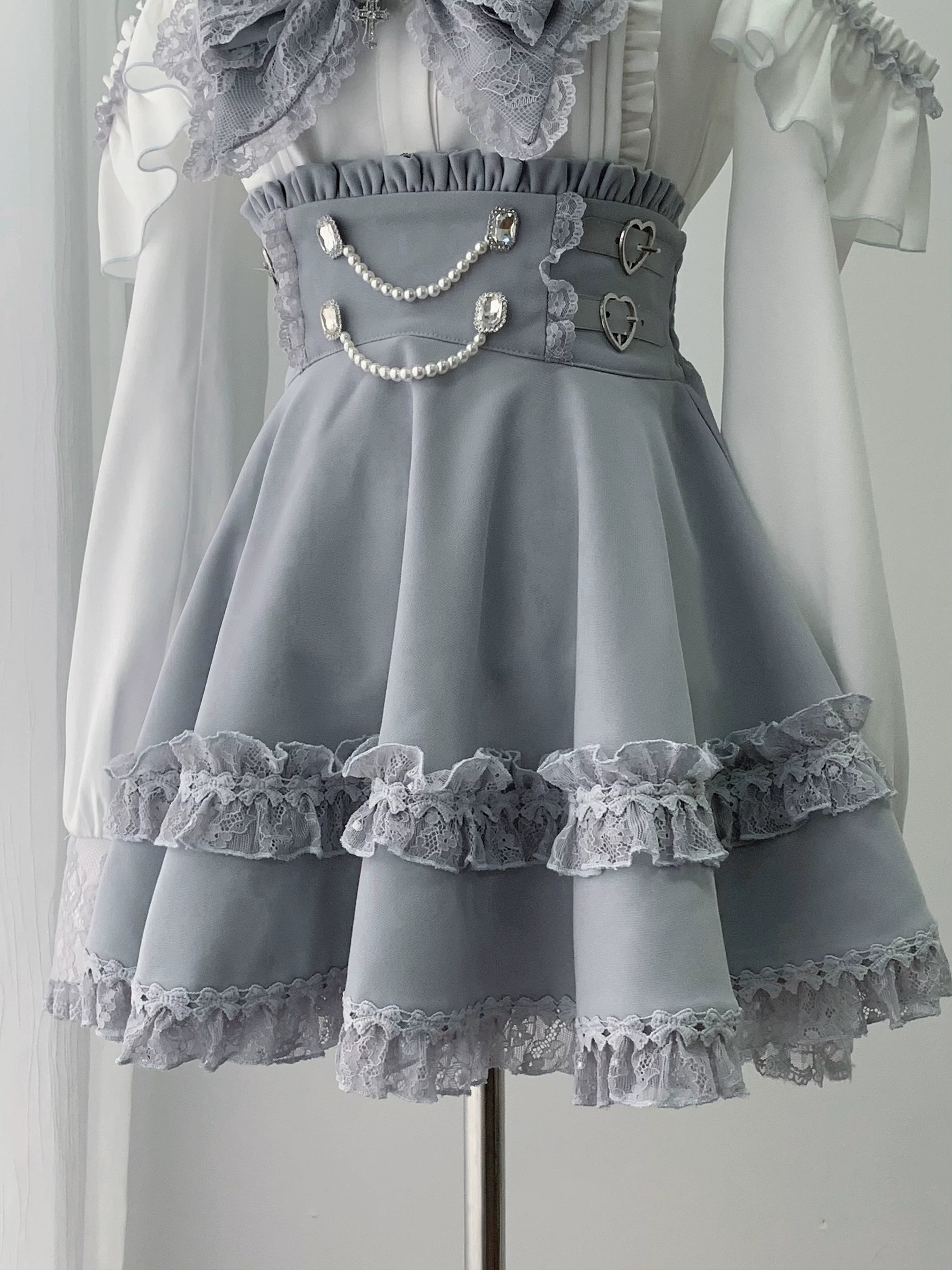 High-waist ryousangata jirai kei skirt in light grey with pearl chain waist decoration heart embellishments multi-layer ruffled lace hem and elastic back construction
