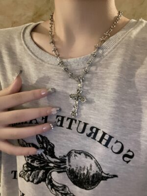 Jirai Kei layered cross pendant necklace worn as neck choker on casual street style outfit, silver metal chain with retro cross charms close-up view