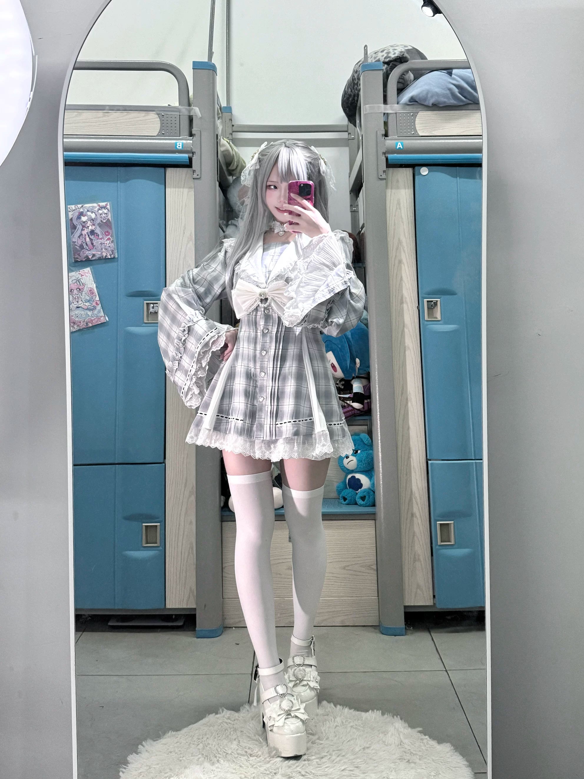 Silver-haired female model wearing gray plaid Jirai Kei hime sleeve dress in mirror selfie front view, showcasing ruffled sleeves, delicate lace trim, and white platform shoes