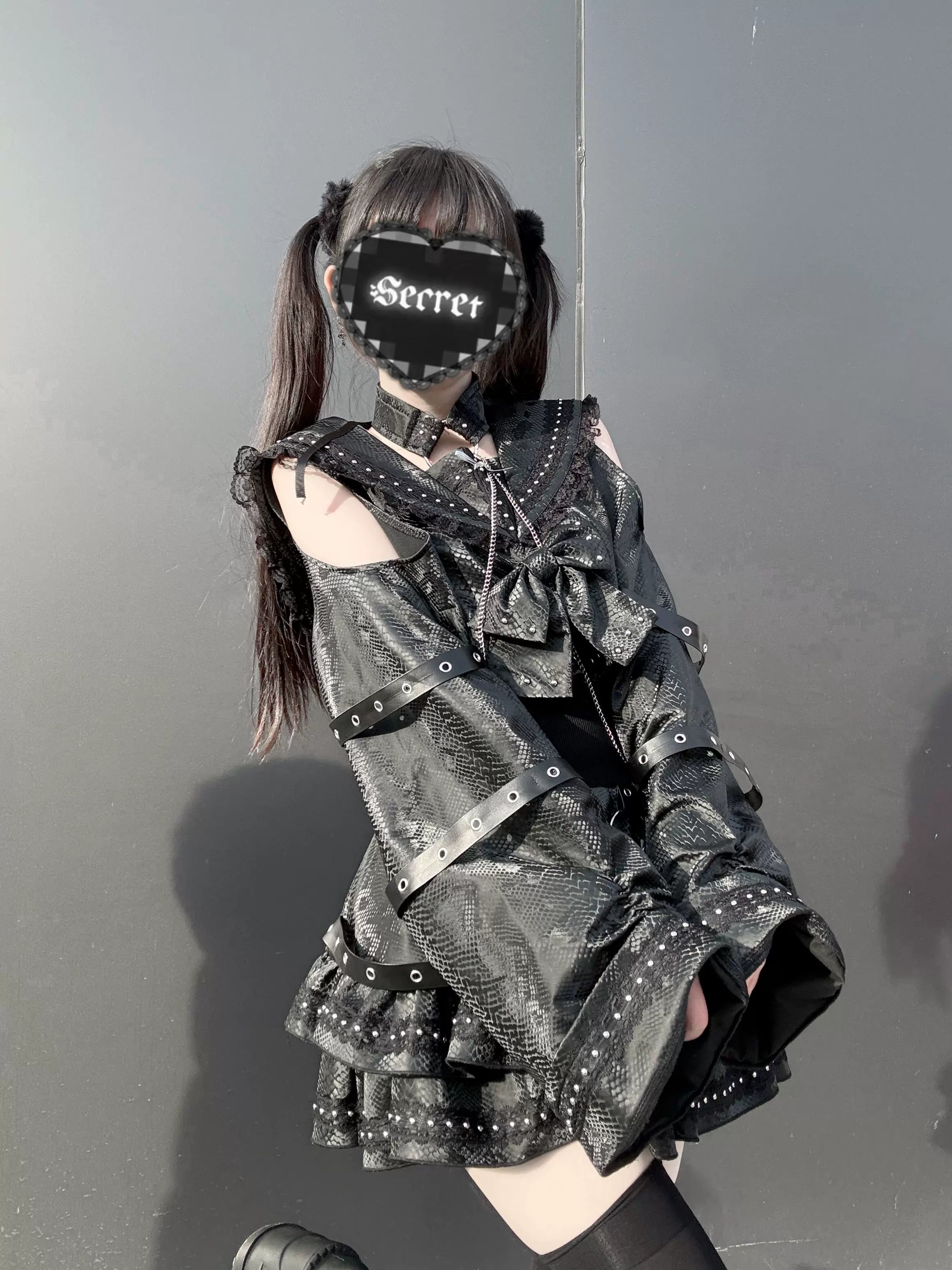 Snakeskin-like PU gothic outfit set side three-quarter view on female model with cold-shoulder sleeves rivet-decorated ruffled skirt and alternative styling