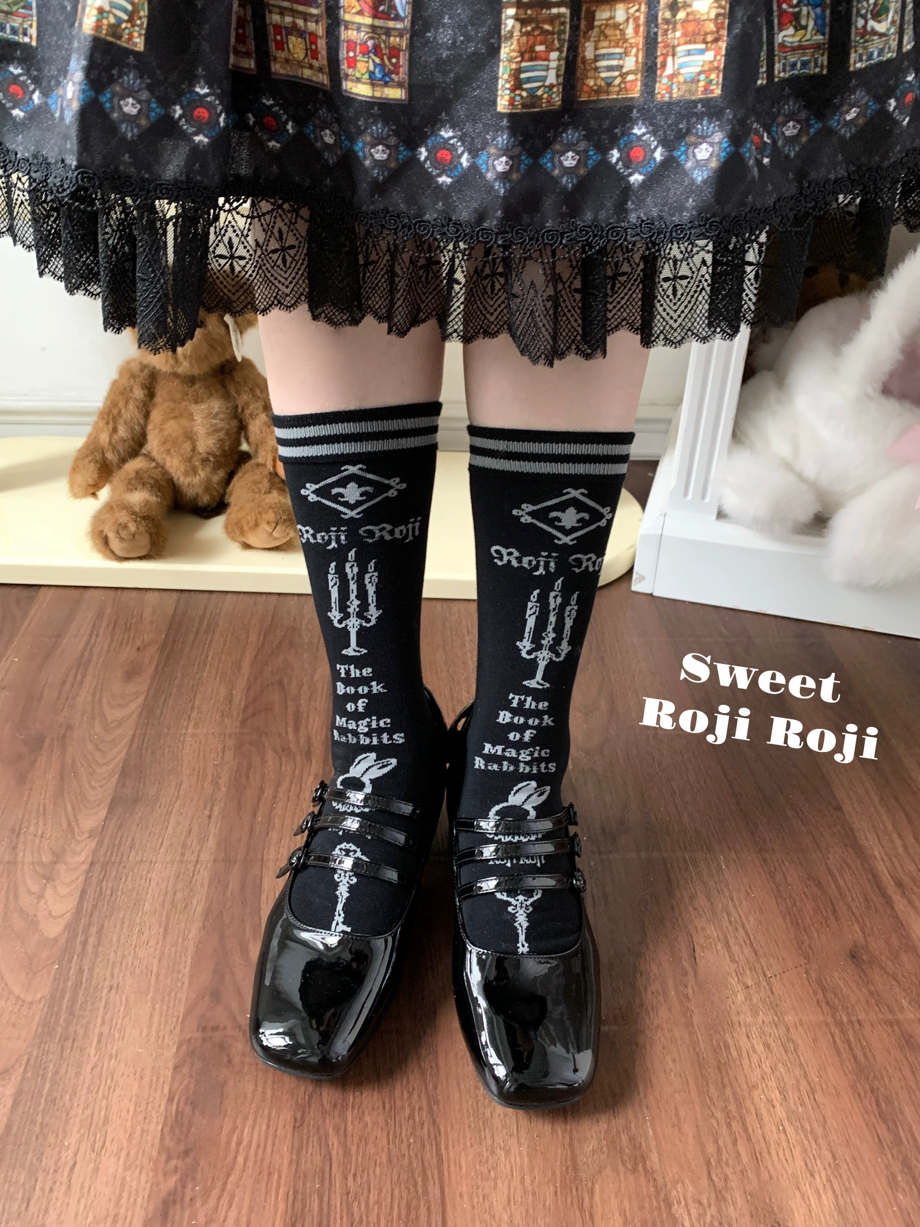 Jirai Kei black mid-calf socks with geometric letter prints and striped cuffs paired with black lace-trim vintage skirt