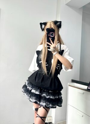 Front mirror selfie of model in black and white layered lace puff skirt with color-block sleeve top and blonde cat ear hair clips
