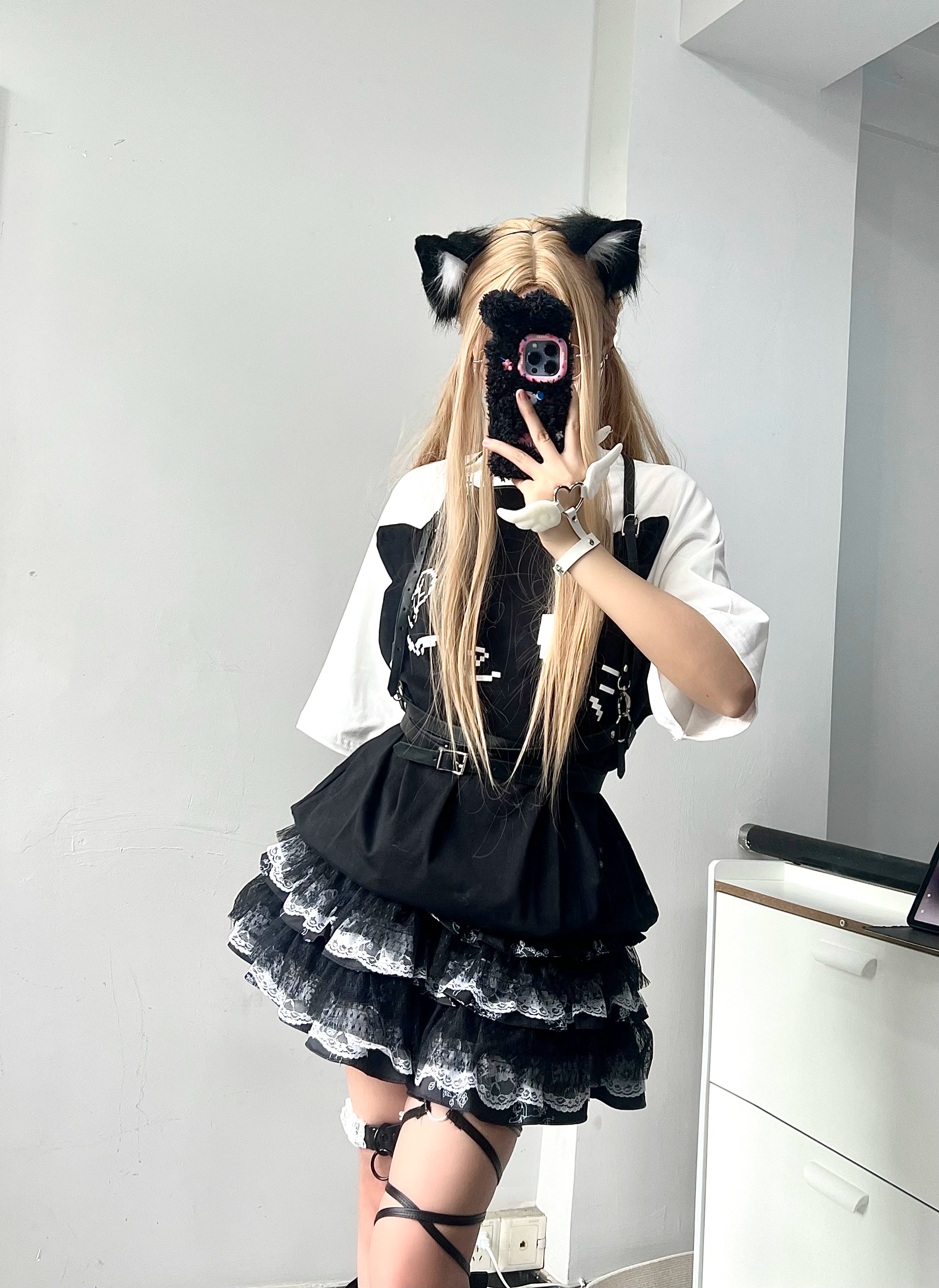 Front mirror selfie of model in black and white layered lace puff skirt with color-block sleeve top and blonde cat ear hair clips