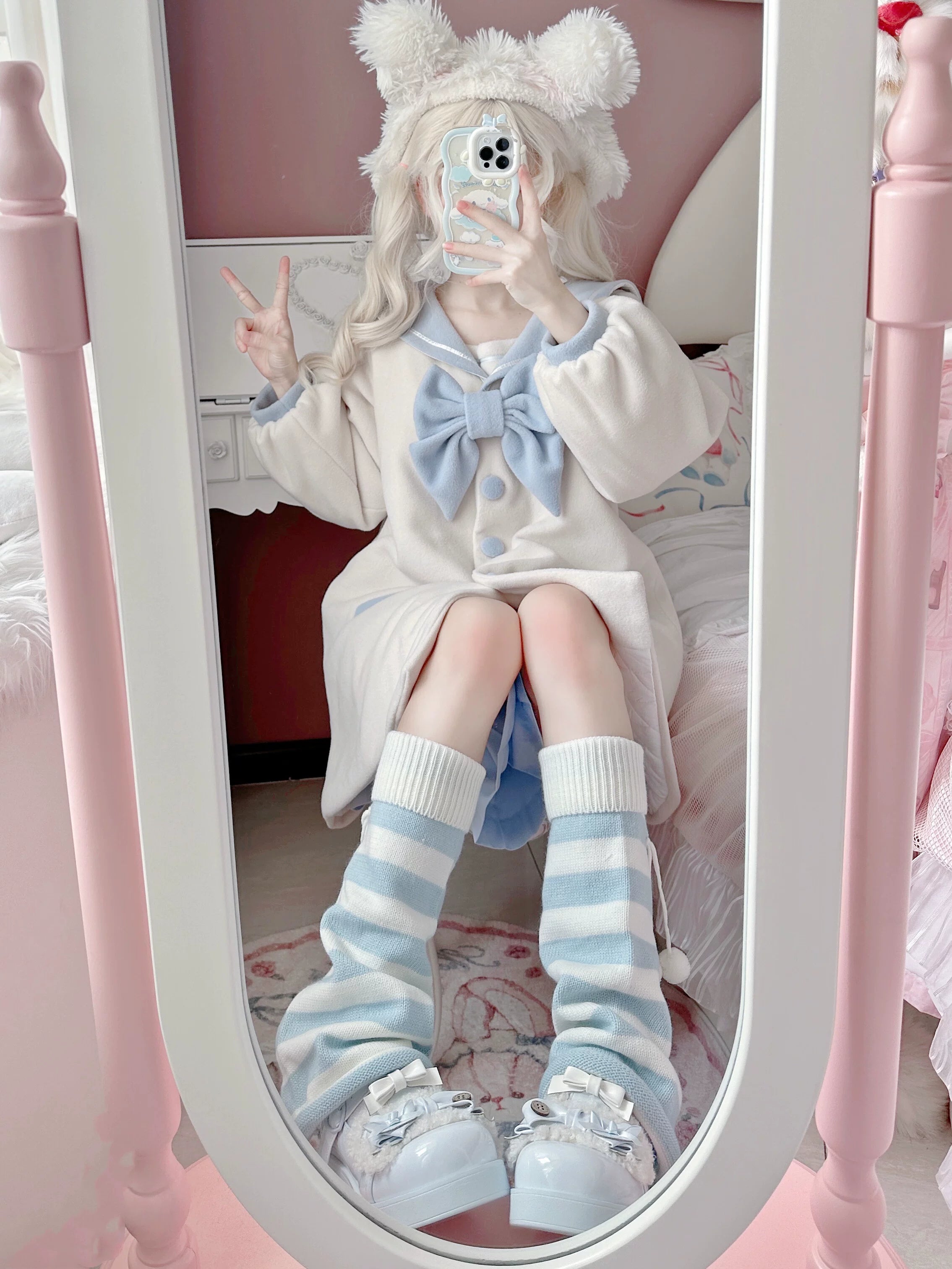 Mirror selfie of Jirai Kei styled girl wearing striped leg warmers with bear ear headwear and pink bedroom interior