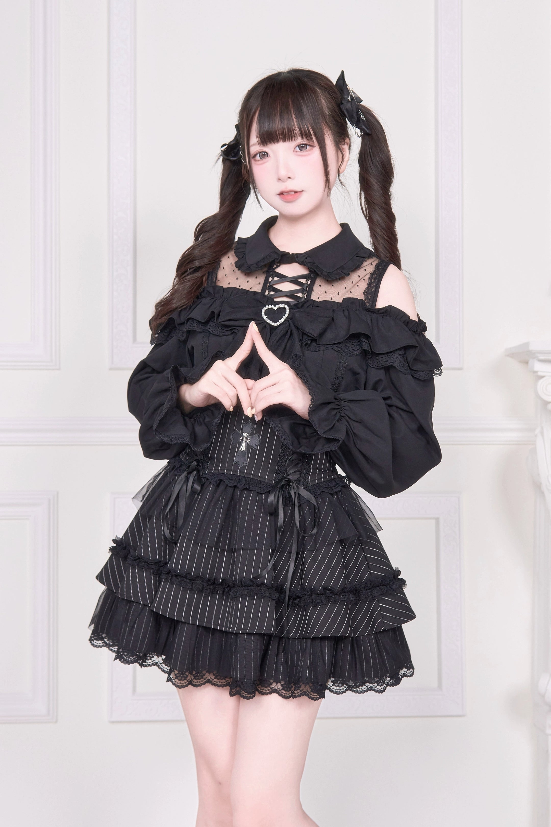 Black cold-shoulder Jirai Kei blouse close-up front view showing lace-up detailing and heart brooch accent