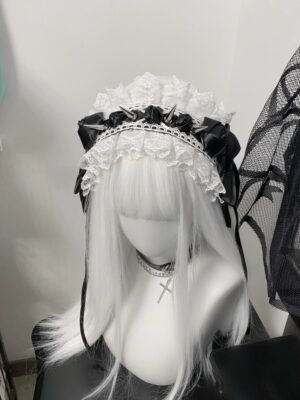 Black Jirai Kei lace headband with metal spikes and satin bows frontal close-up view on mannequin