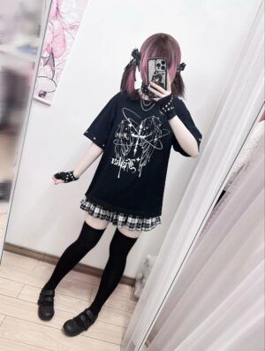 Back three-quarter view of oversized black Jirai Kei t-shirt with wing print, model wearing studded fingerless gloves and plaid mini skirt, mirror selfie bedroom aesthetic