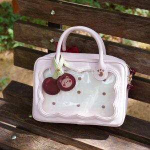 Soft pink cherry bear cookie Jirai Kei crossbody bag with polka dot clear window and cute bear pendant charm flat lay view