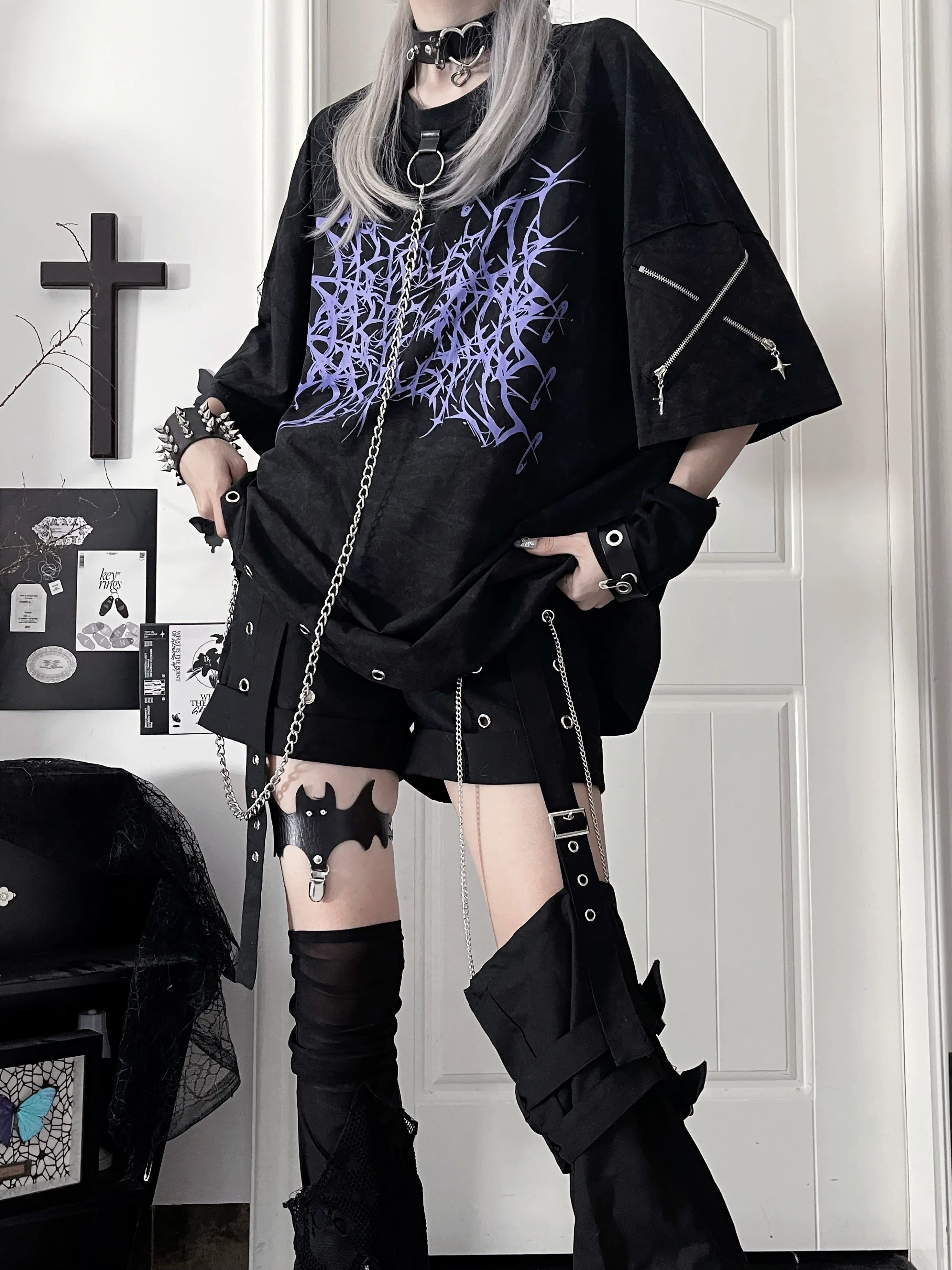 Black oversized Jirai Kei cotton t-shirt with purple thorn print and detachable metal chain, full-body front view in gothic studio setting
