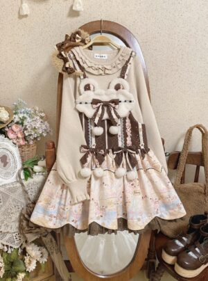 Brown corset bodice Jirai Kei jumper dress on hanger showing fuzzy bear applique and ruffled lace hem detail against vintage home background with floral ornaments