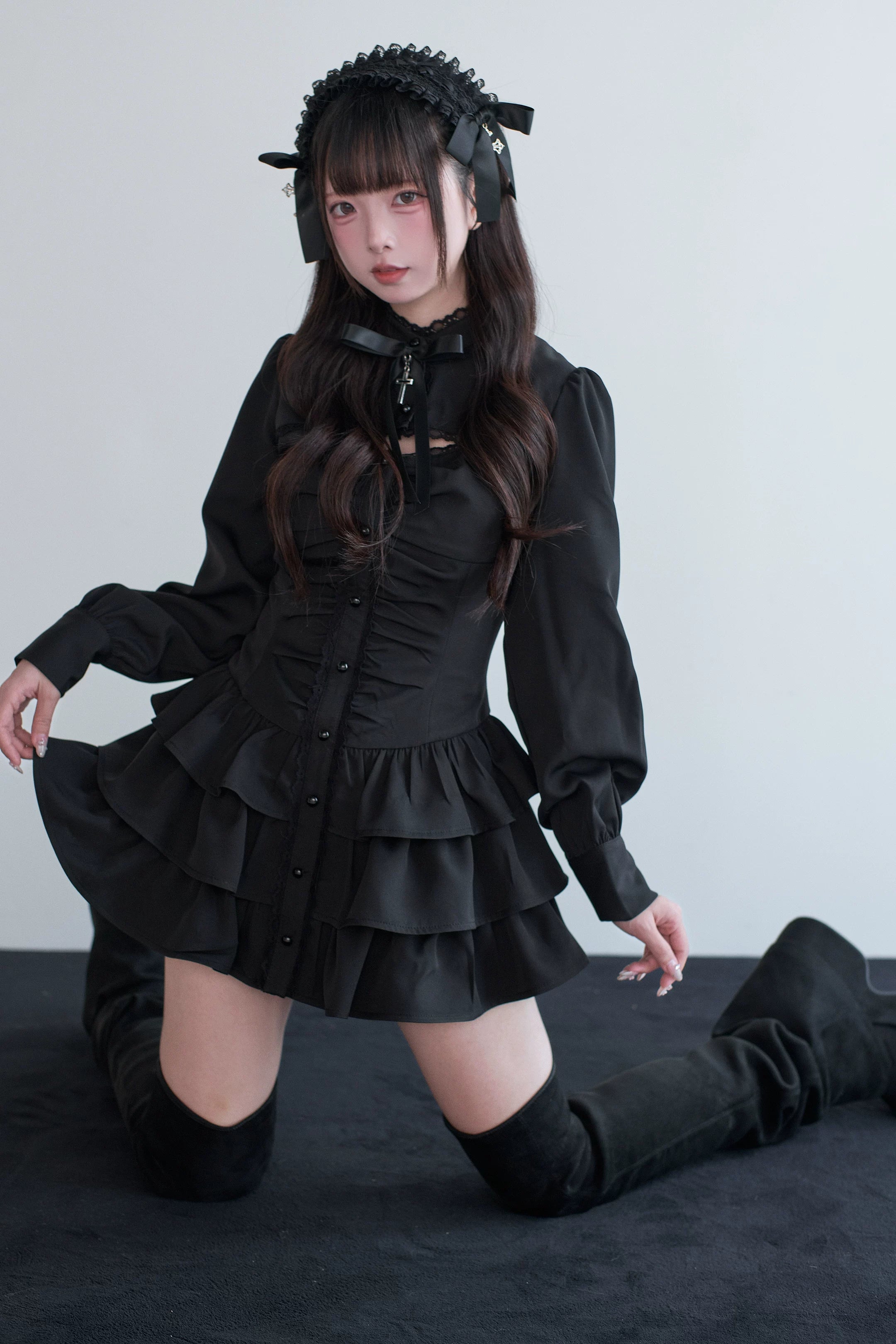 Side view of black Jirai Kei gothic dress kneeling pose showing puff long sleeves and skirt silhouette