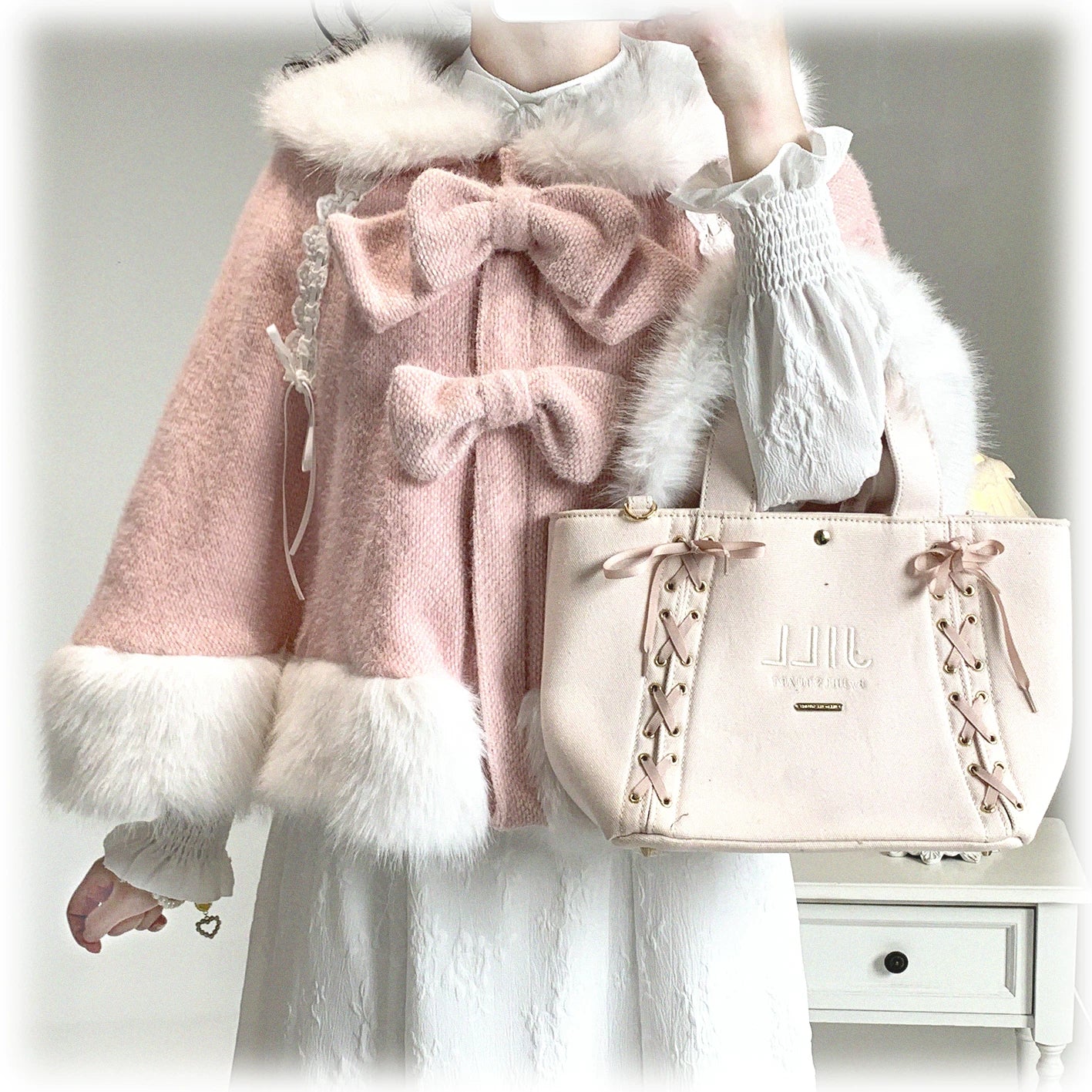 Pink Jirai Kei bunny ear winter cape half-body model shot featuring double fluffy bows fuzzy collar and hem paired with delicate lace top and handbag