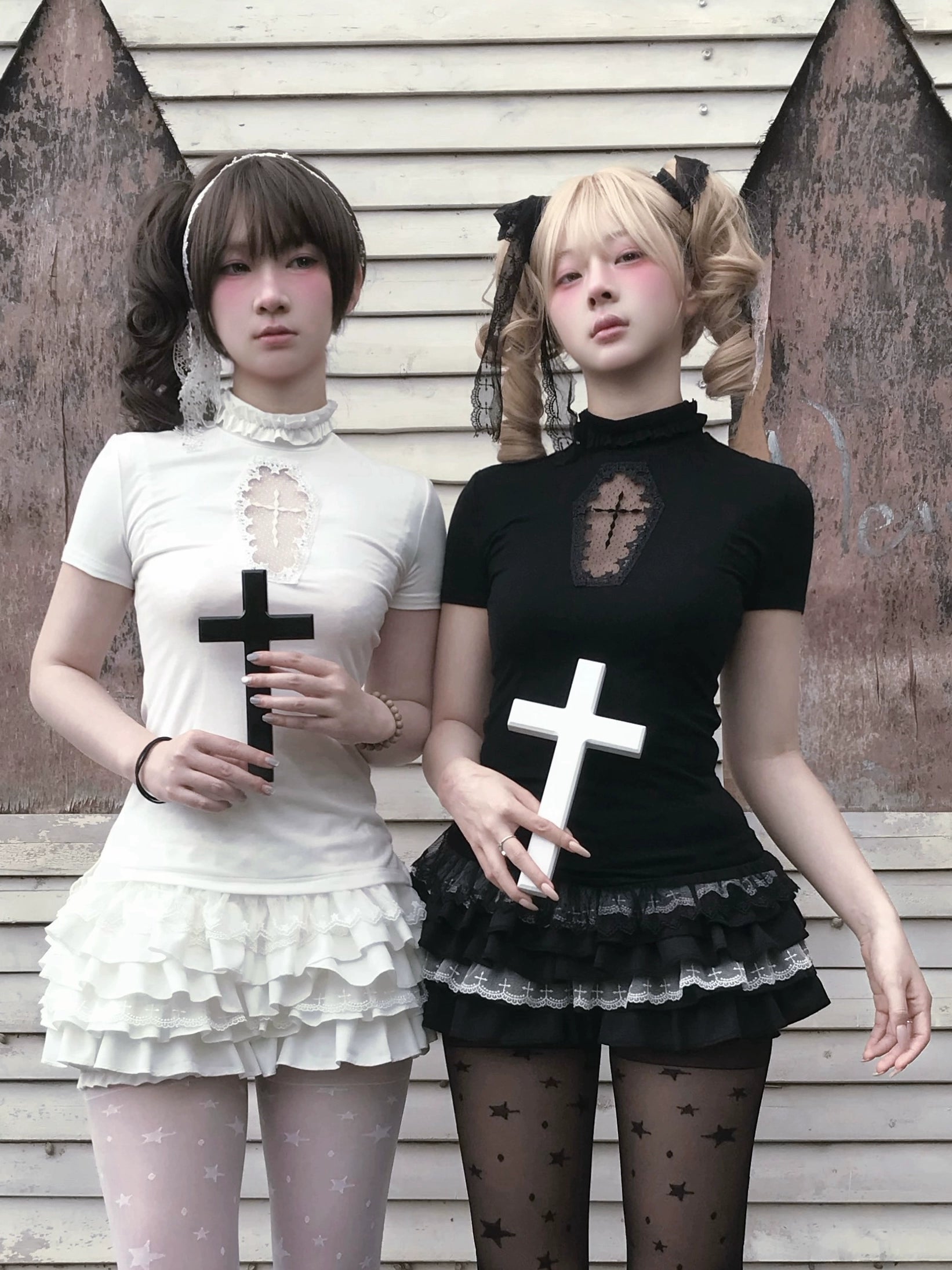 Gothic Jirai Kei cross-embellished top and tiered ruffle bloomers front view on two models with wooden wall background