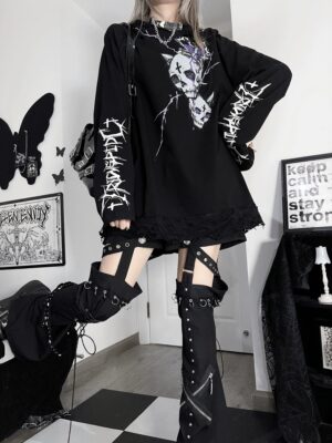 Female model wearing oversized black jirai kei gothic hoodie with skull and thorn prints in side profile full body view showcasing raglan sleeves and distressed design