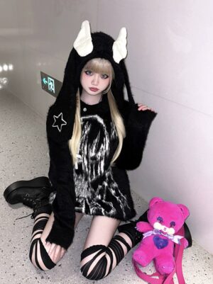 Black jirai kei bunny ear wing hooded sweater with star embroidery and anime ghost print worn in indoor elevator hallway with pink teddy bear styling