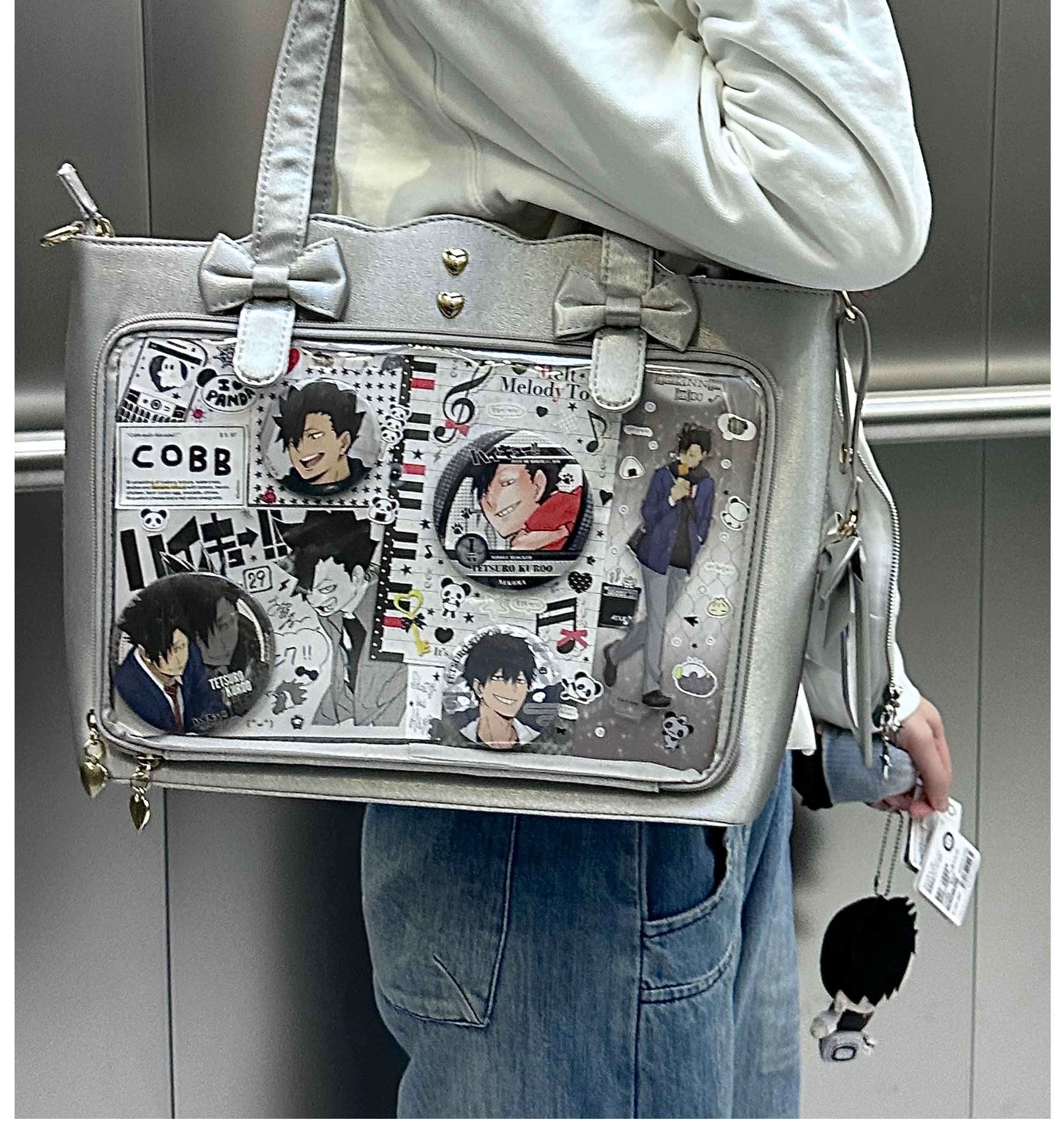 Jirai Kei ita bag side profile view displaying the distinctive wavy edge silhouette, bow-adorned shoulder strap design, transparent anime pin window, and heart metal stud placement along edge