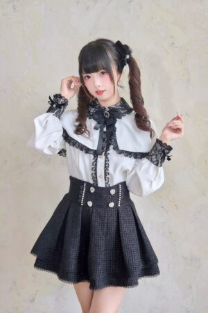 Front half-body view of jirai kei skirt with lace-trimmed blouse featuring cape collar, neck bow brooch, and rhinestone heart embellishments at waist