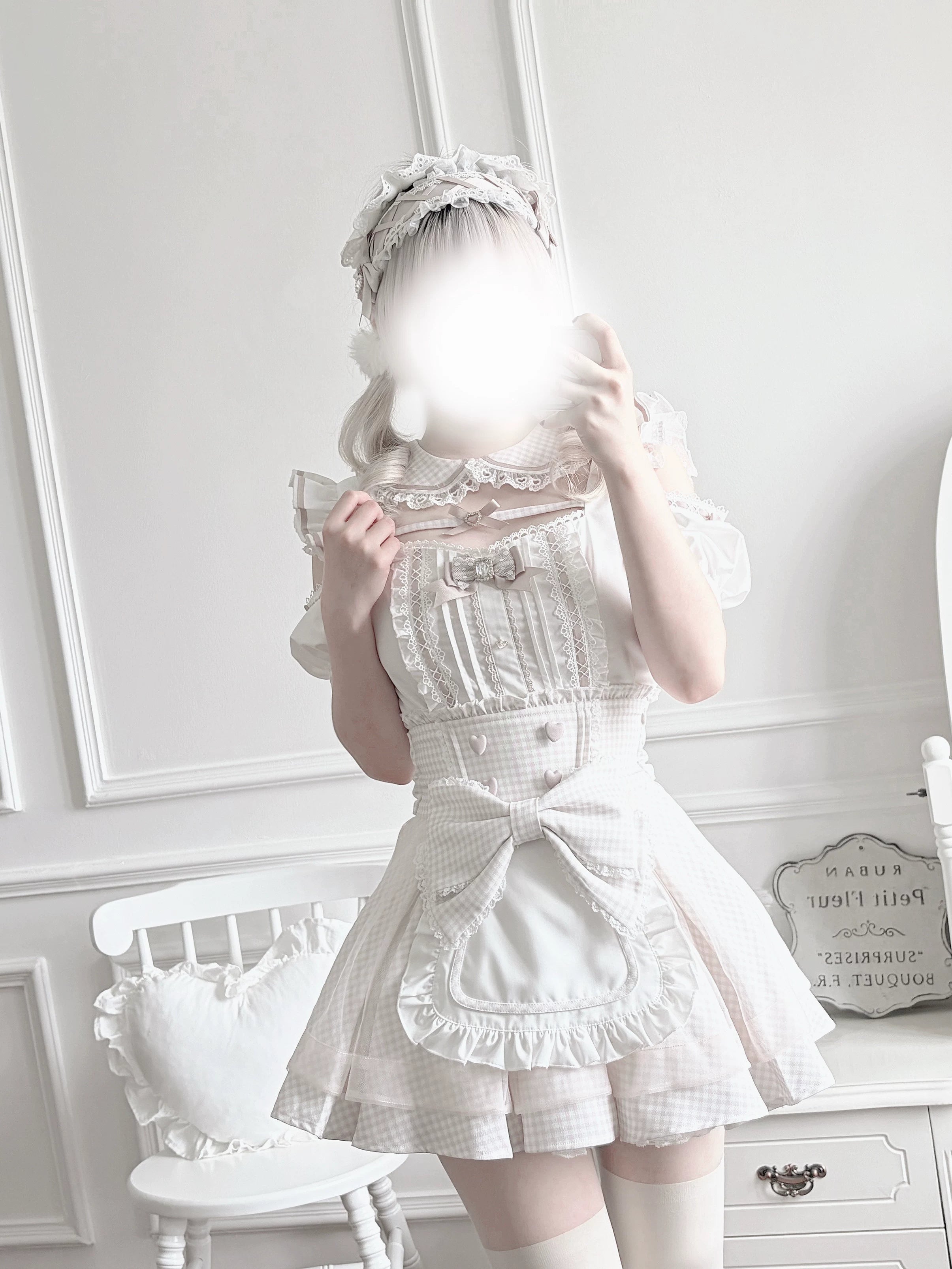 Close-up detail view of heart-shaped button closures and front-facing design elements on pink gingham Jirai Kei maid skirt