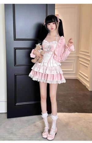 Ryousangata pink cardigan lace skirt set with cat print camisole worn by model with twin tails, front full-body view indoors