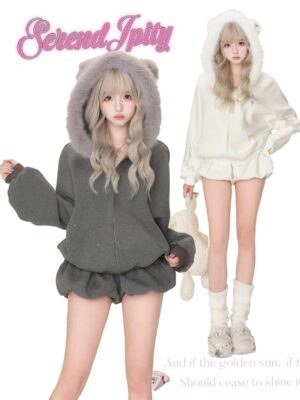 Three-quarter front angle of grey fuzzy bear ear hooded jacket with cross rhinestone pattern and full front zipper, worn by blonde model