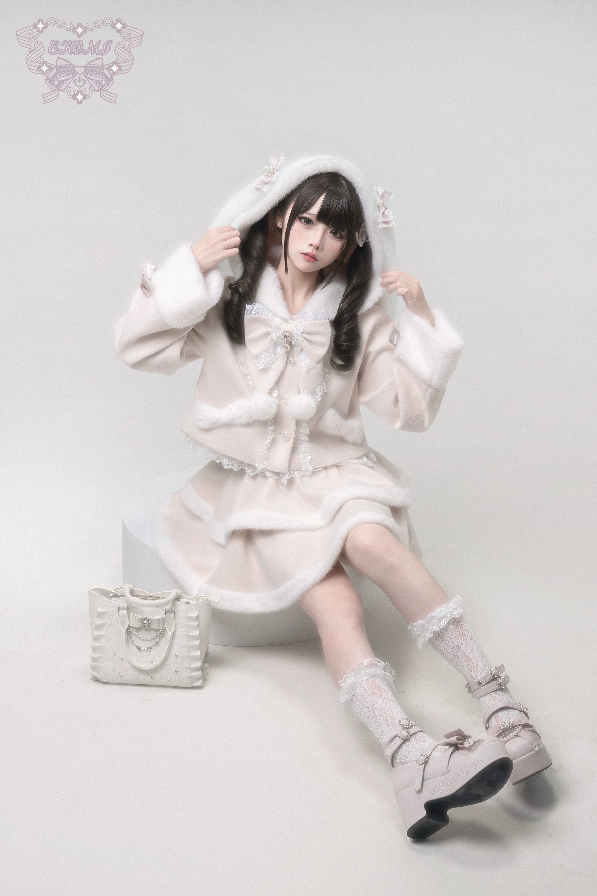 Ryousangata Jirai Kei outfit with detachable bunny ear hood front sitting pose view, matching handbag nearby, lace socks and platform shoes, tiered ruffle skirt aesthetic