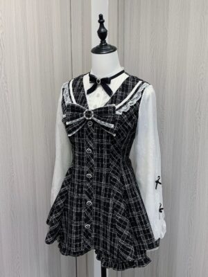 Black and white plaid Jirai Kei dress with double-layer chiffon sleeves, Peter Pan lace collar, detachable velvet bow, front button closure, and matching ruffle hem shorts - front three-quarter view on mannequin