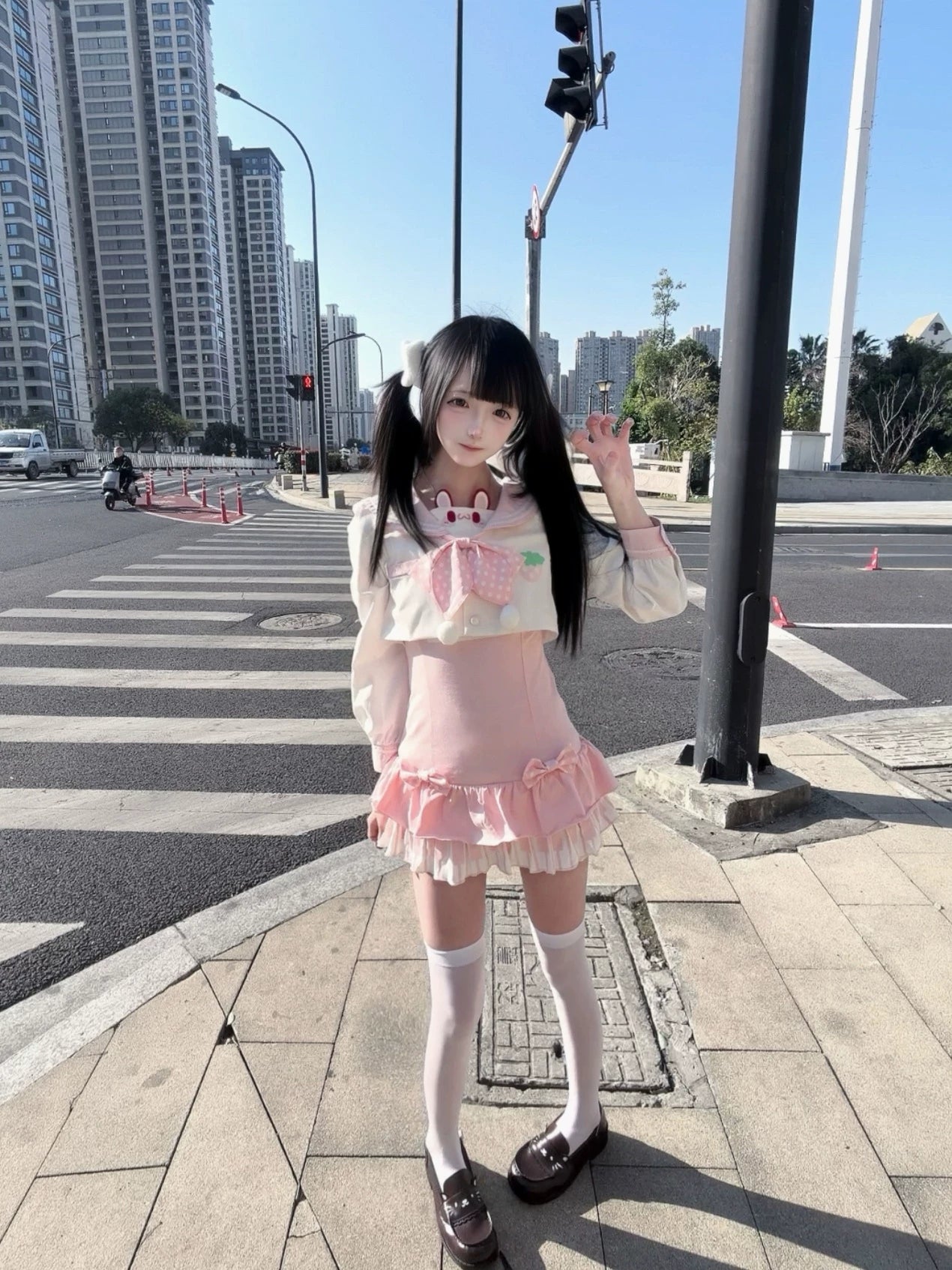 Full-body front side angle of complete Jirai Kei sailor collar outfit with pink ruffle tiered mini skirt, white thigh-high socks, brown loafers, rabbit bow detail on urban sidewalk