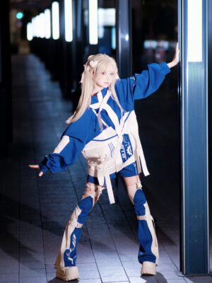 Blonde model wearing cyberpunk jirai kei outfit set with blue white color block jacket strap harness and matching leg guards in night neon street scene