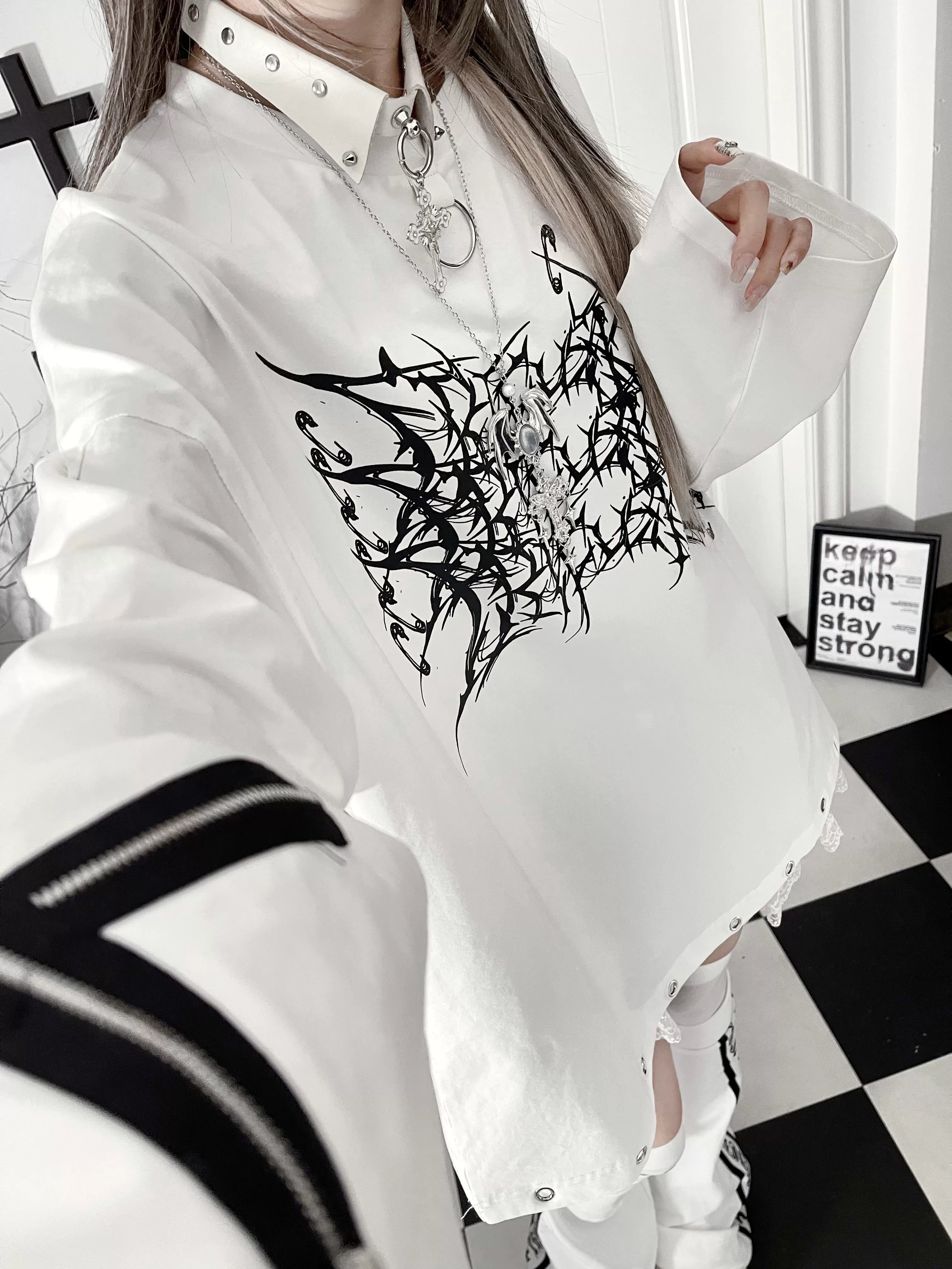 Detailed product photography of jirai kei gothic long-sleeve tee showing thorn cross print clarity, fabric texture, crew neck construction, and oversized fit proportions