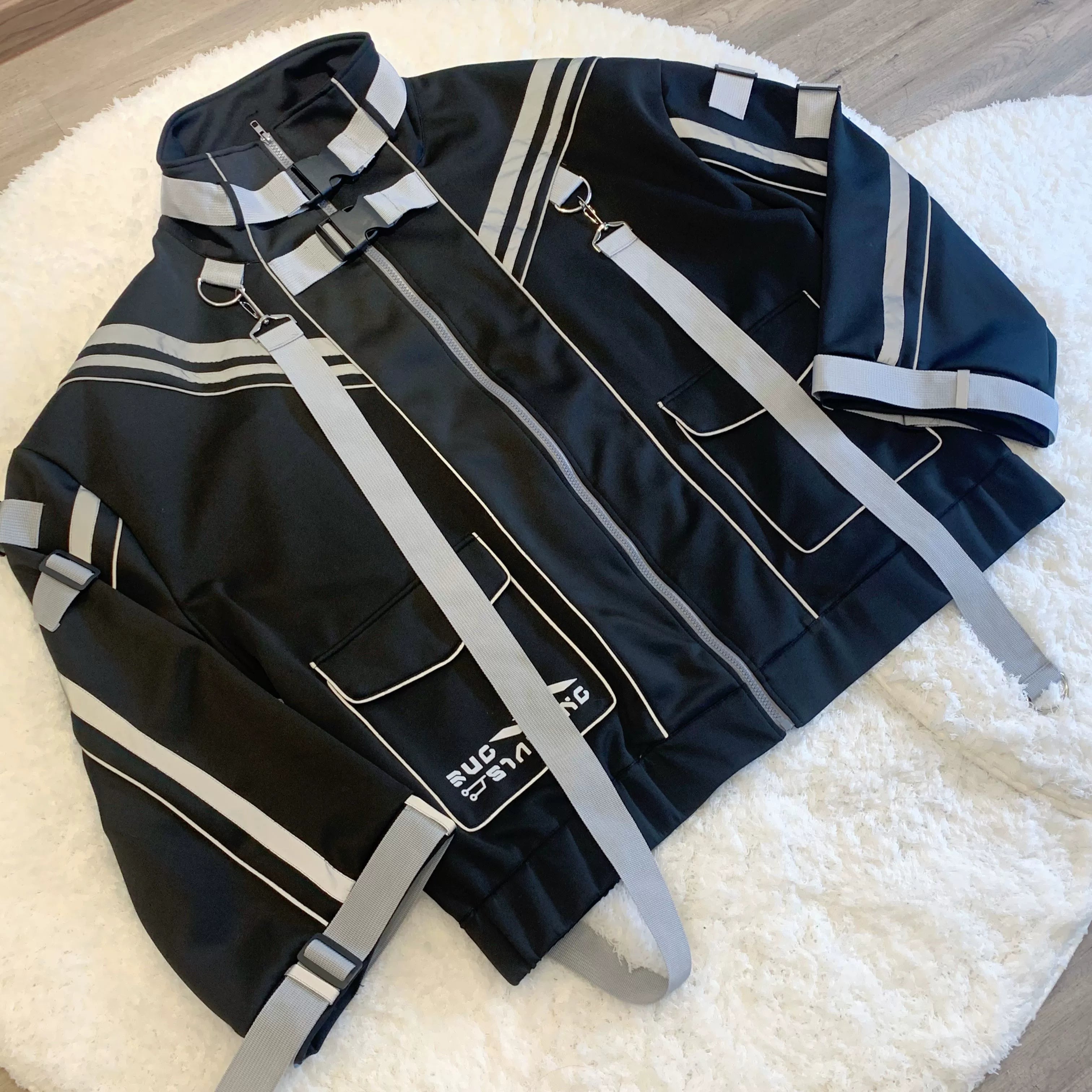 Black Jirai Kei oversized punk techwear jacket removable webbing reflective strips cargo pockets detail front view