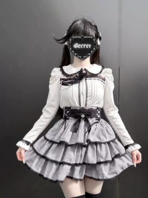 White blouse with black tiered ruffle skirt two-piece Jirai Kei set on single model, displaying puff sleeves and plaid layered skirt with lace accents